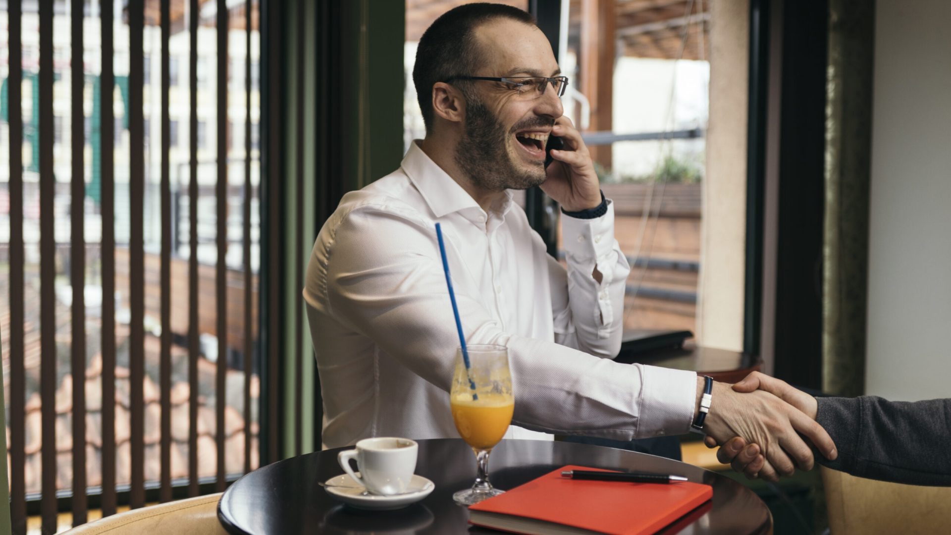 cheerful-businessman-seaking-phone-shaking-hand